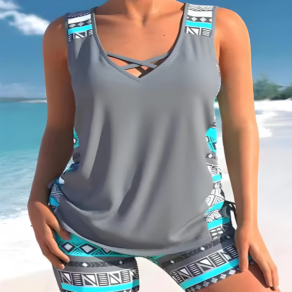 Women's blue two-piece swimsuit with floral lace print, showing top and briefs.
