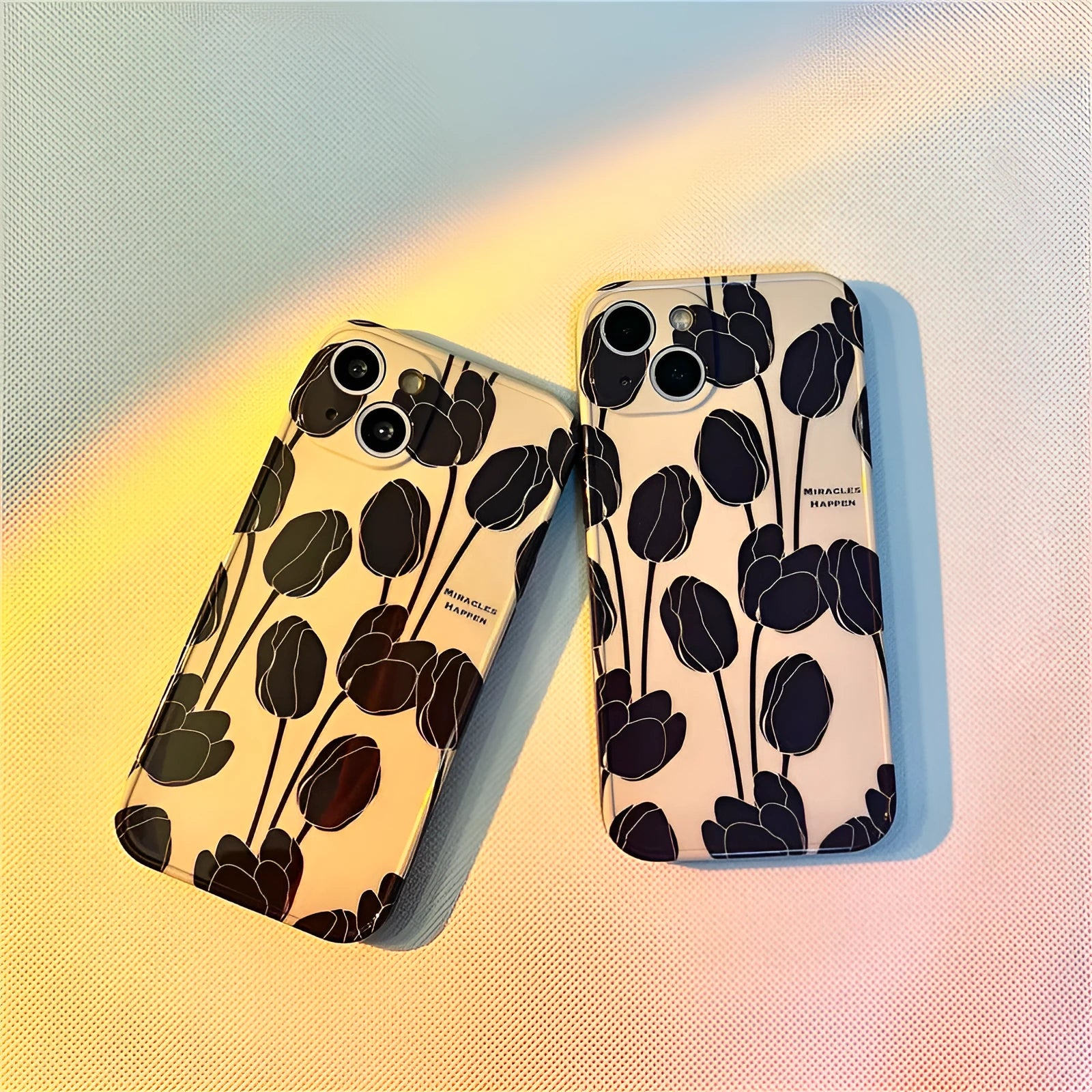 Black silicone iPhone case with a detailed white tulip pattern on the back.