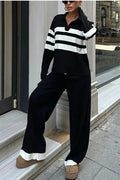 Women wearing black and white striped polo collar two-piece set with matching trousers