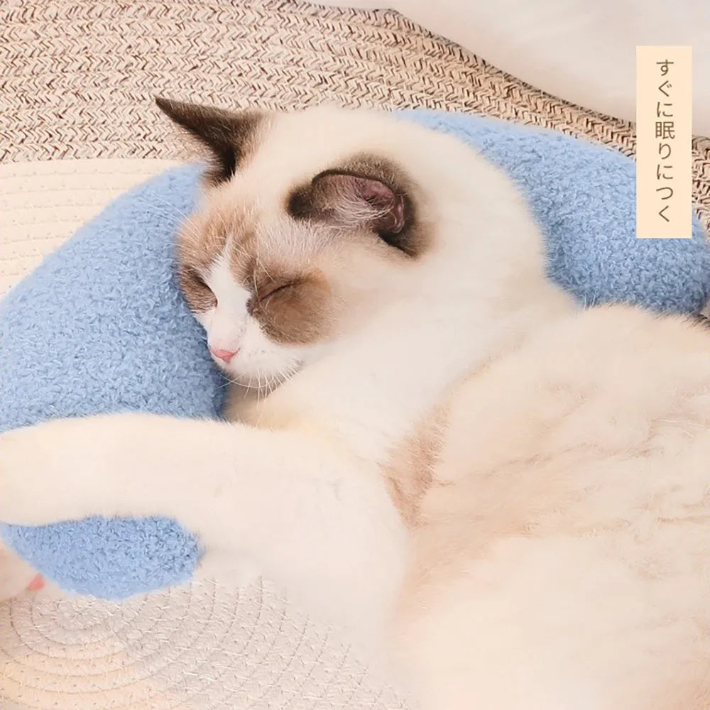 Blue U-shaped cat pillow with an adjustable fabric collar for neck support on a grey sofa