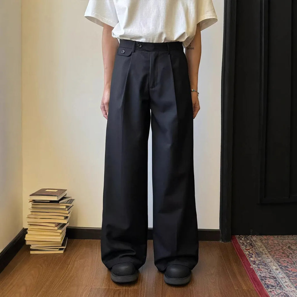 Men's straight-leg wide trousers in black, showing casual suit pant style with draping fabric.