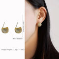 Gold or white geometric drop-shaped clip earrings with spherical bead elements