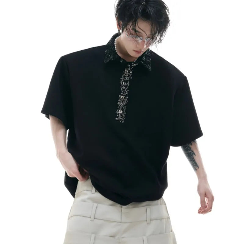 Men's black loose-fit polo shirt with heavy embroidery and sequin detailing on the front.