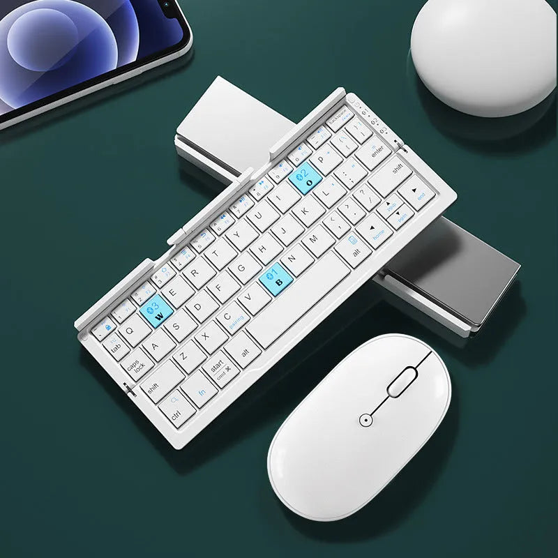 Aluminium folding Bluetooth keyboard with stand supporting smartphone, showing compact folded size