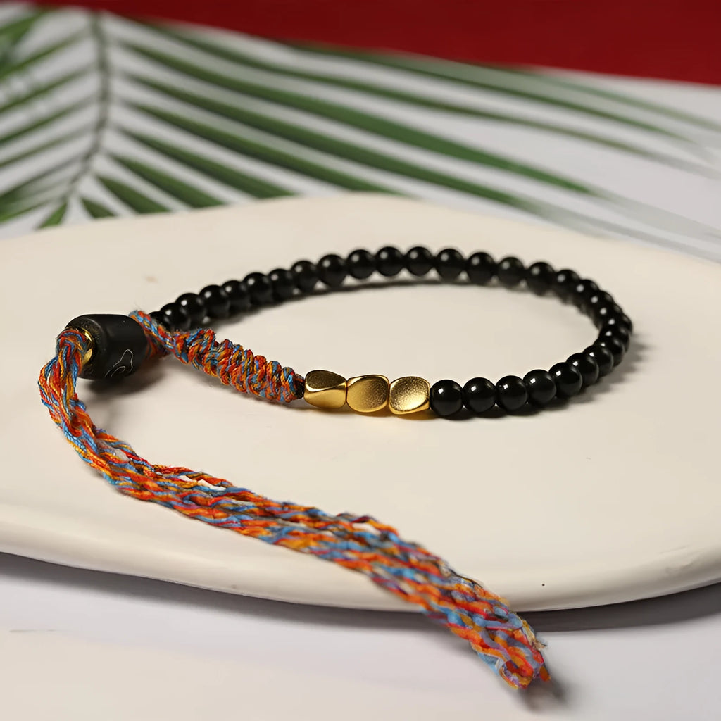 Hand-woven obsidian-coloured strap bracelet showing textured surface and slim 4mm width