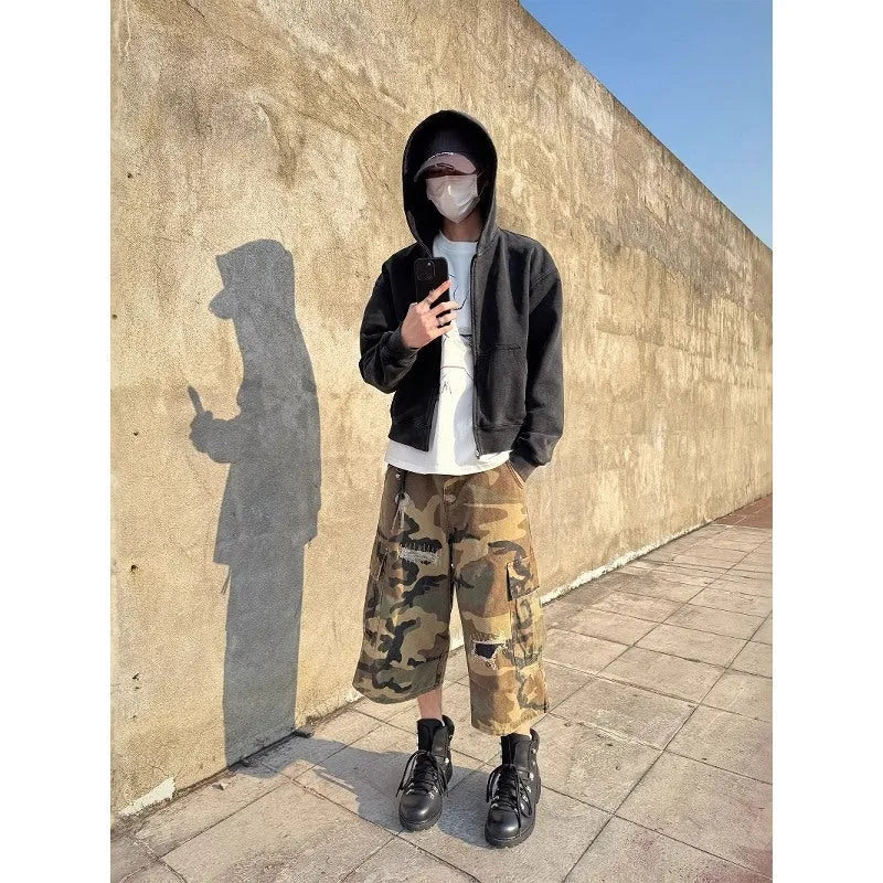 Men's retro patch ripped camouflage cropped jeans showing loose straight leg fit and distressed detailing