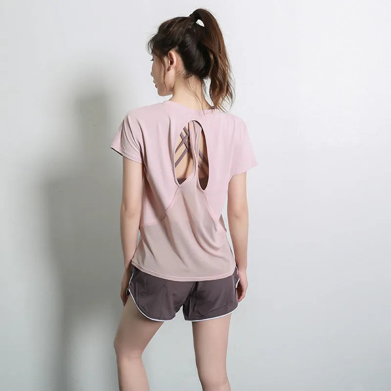 Women's short sleeve polyester sports t-shirt in pink, shown in a casual athletic style.