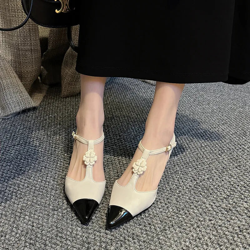 Women's black sheepskin stiletto heel shoe with flower buckle detail on a pointed toe.