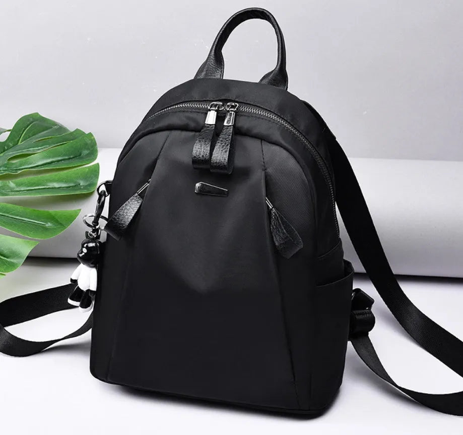 Medium-sized wine red Oxford cloth rucksack with double shoulder straps and a front digging bag.
