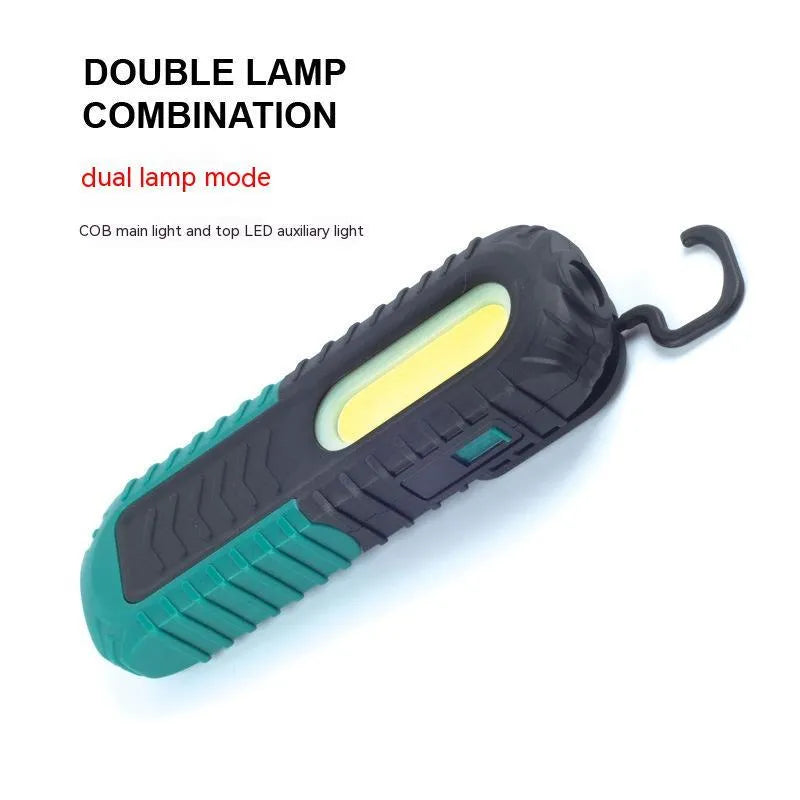 Black and green USB rechargeable automotive inspection work light on a workshop bench.