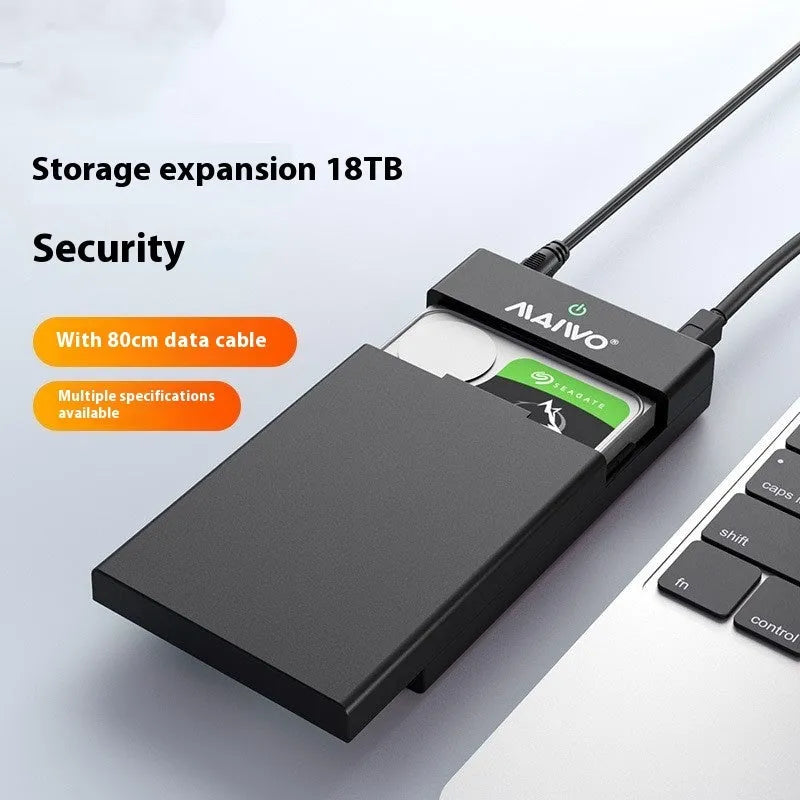 Black and silver 3.5 inch USB SATA hard drive enclosure with power supply and cable on a desk.