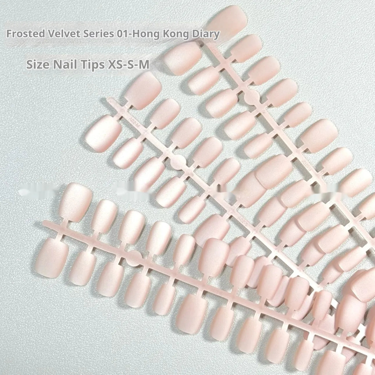 Set of frosted velvet cat's eye effect artificial nails in short ladder shapes on a clear background.
