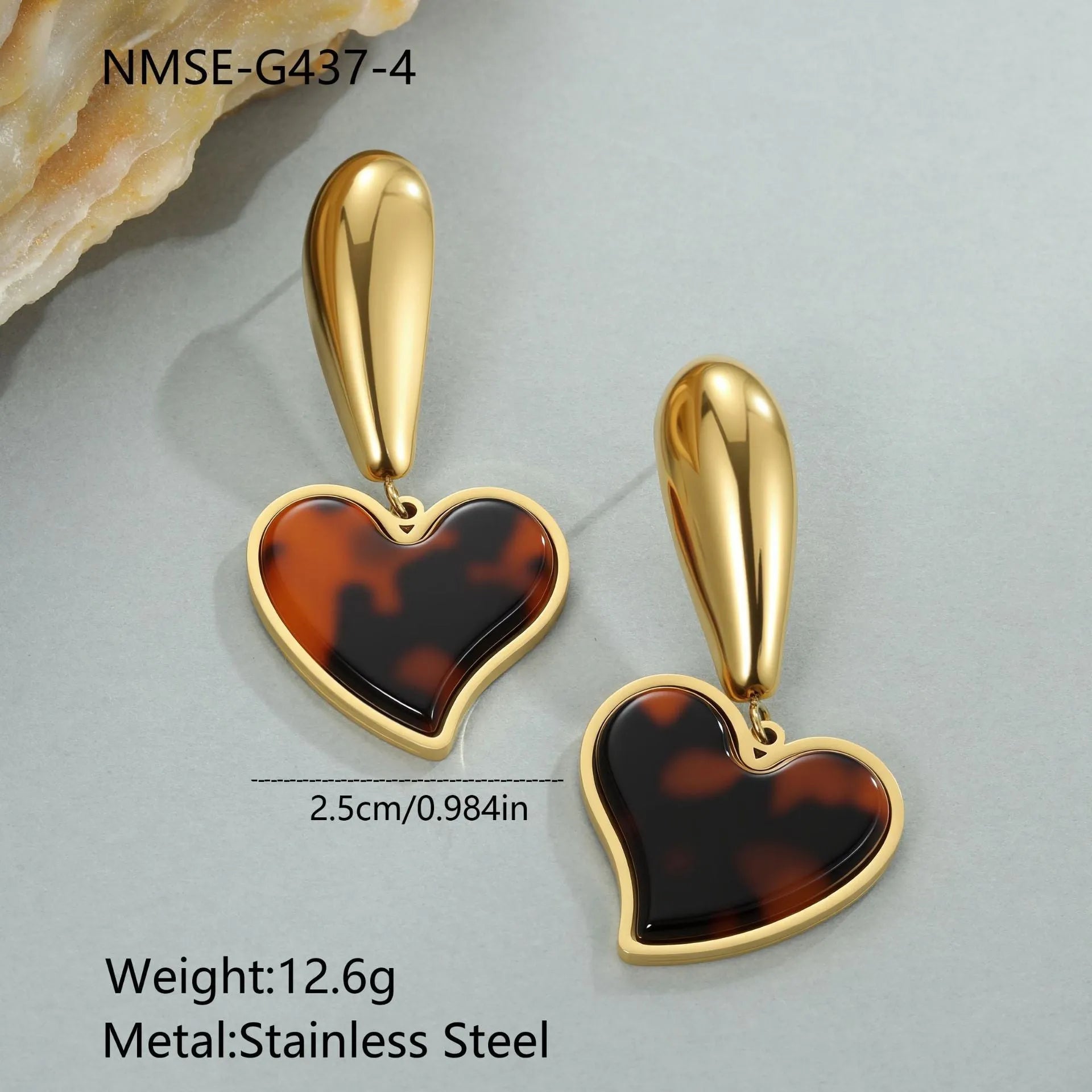 Close up of 18K gold plated stainless steel earrings featuring tortoiseshell resin in heart and flower geometric shapes for women.
