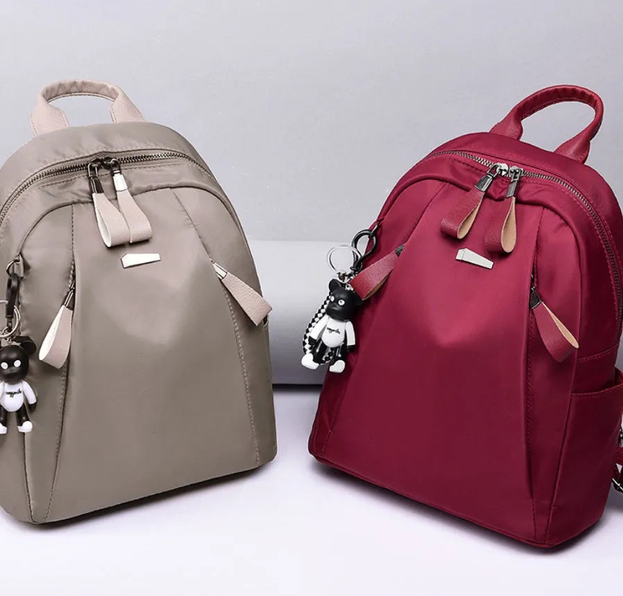 Medium-sized wine red Oxford cloth rucksack with double shoulder straps and a front digging bag.