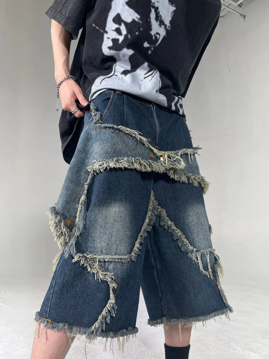 Blue men's loose-fit denim shorts with a frayed five-pointed star detail on the leg, showing American retro style.