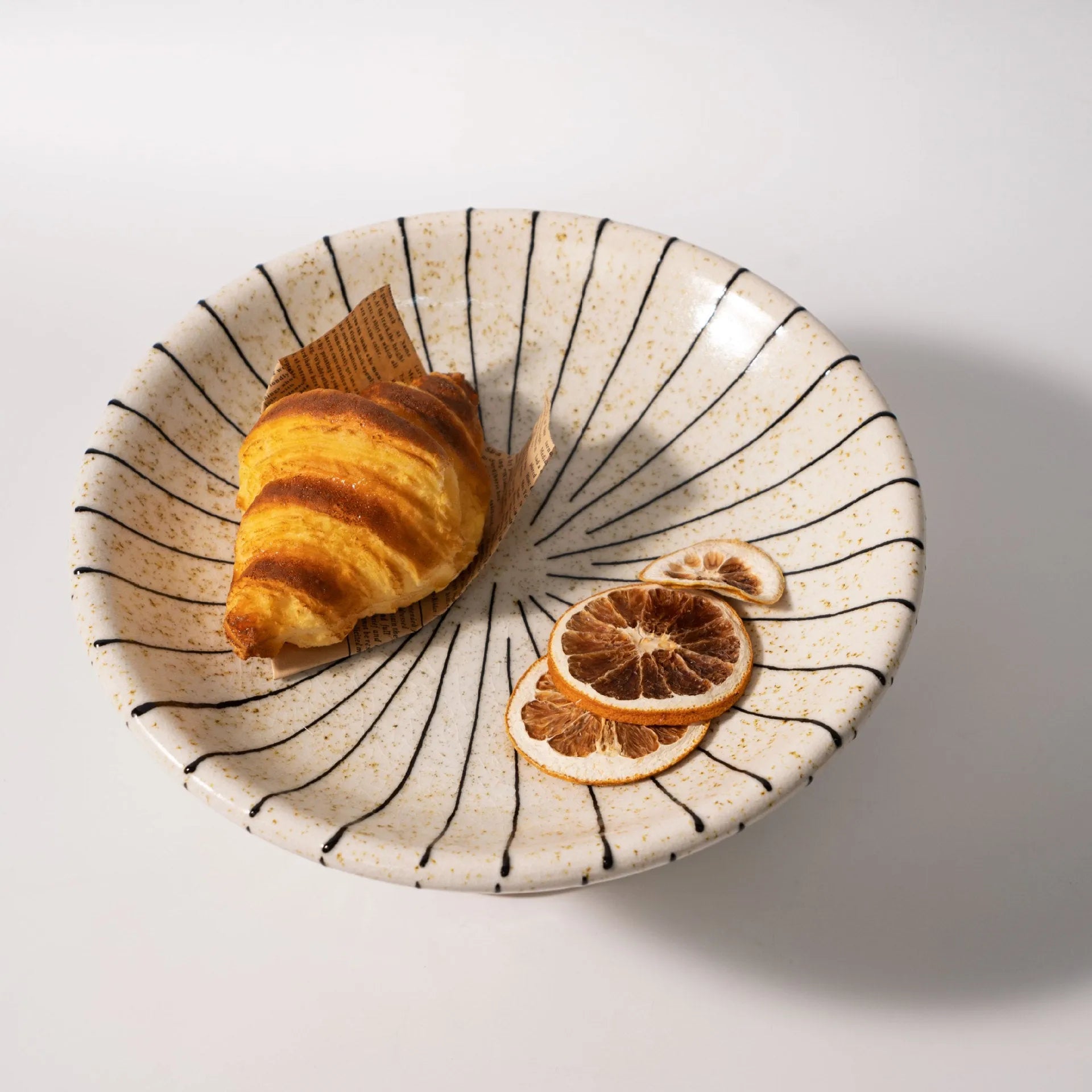 Black and white striped plastic resin dessert plate on a table.