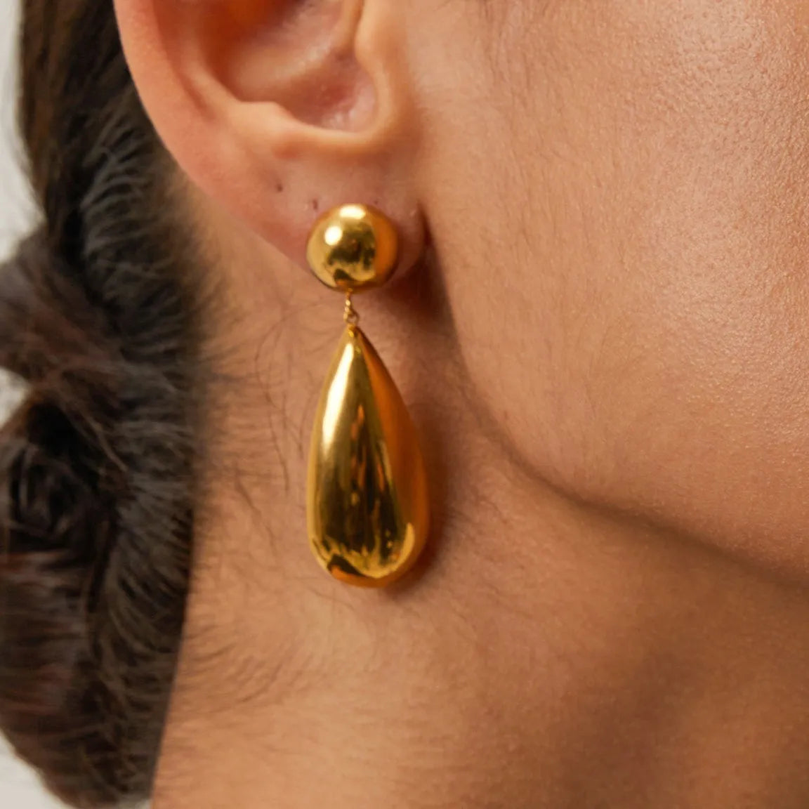 Gold electroplated stainless steel earrings with geometric hemisphere and water droplet pendant design