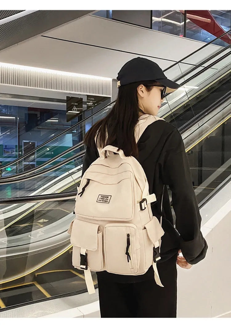 Black and white soft nylon student backpack with laptop compartment and external pockets.