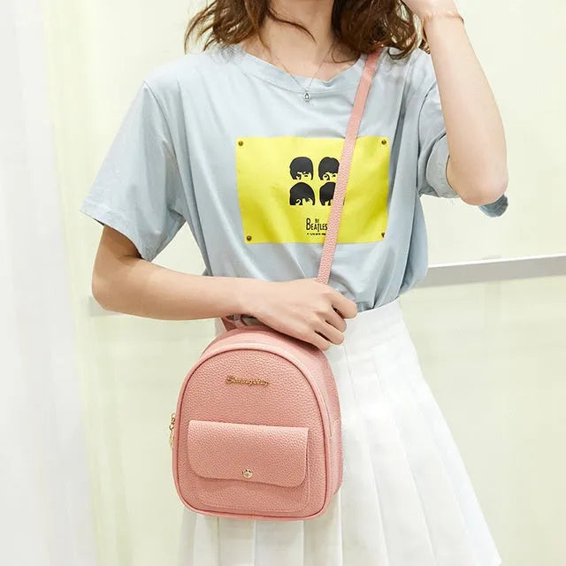 Small black PU women's backpack purse shown as a shoulder bag, with zipper closure and compact size.