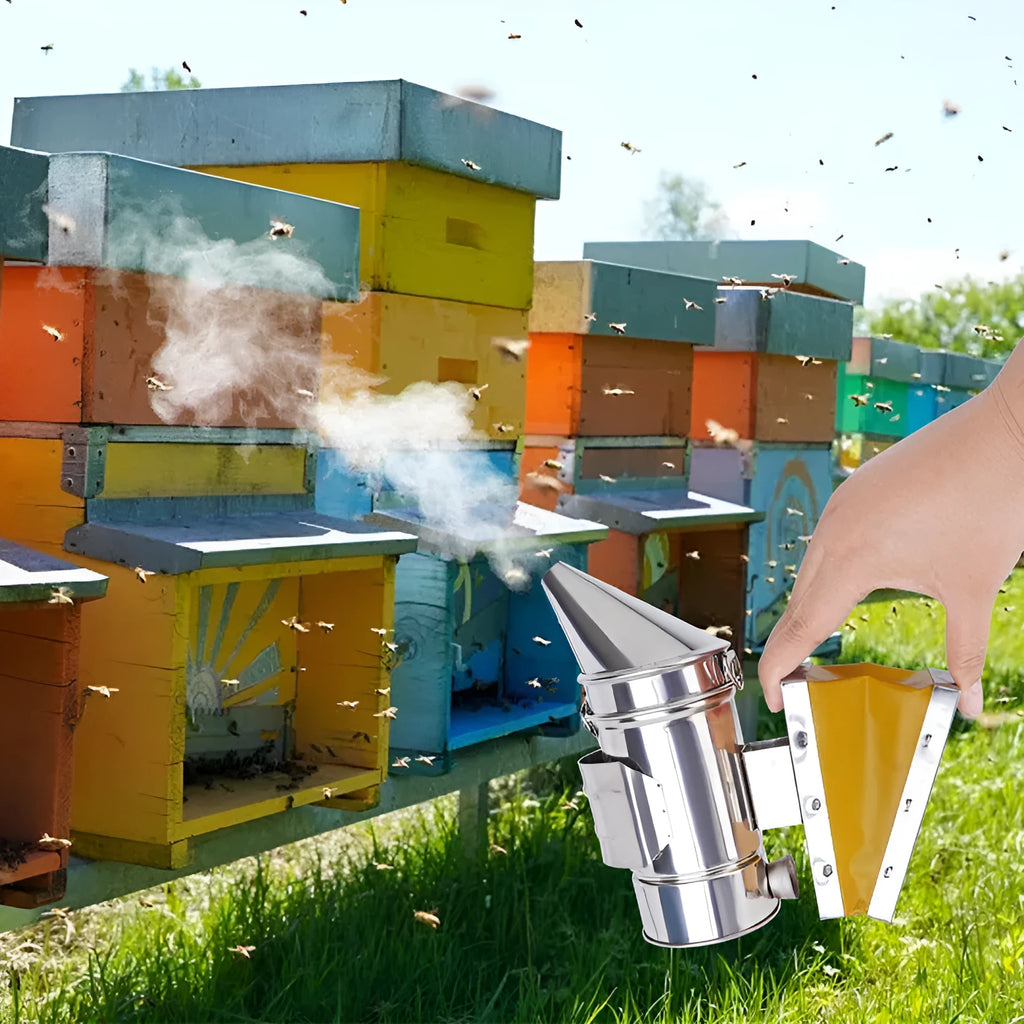 Portable stainless steel beekeeping smoker with leather bellows on a wooden surface