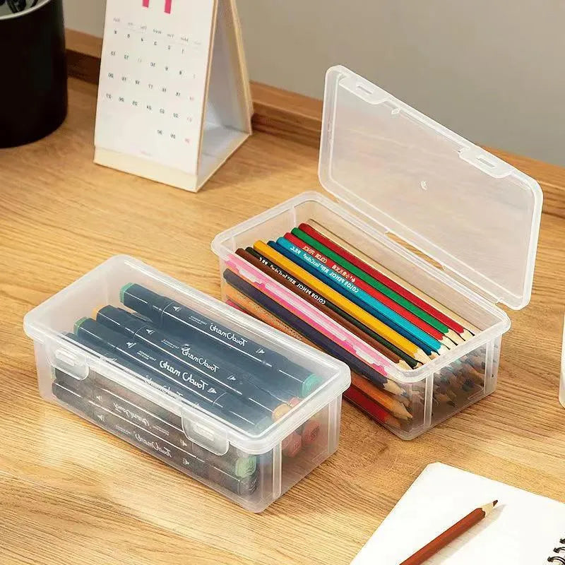 Clear plastic pencil storage box showing coloured pencils and drawing tools inside.