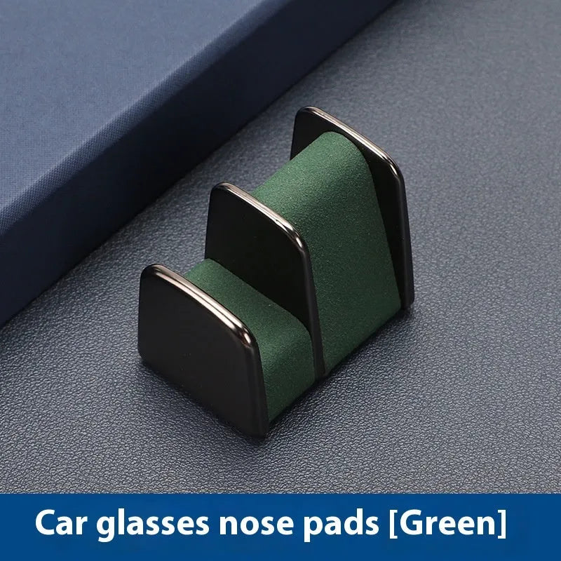 Zinc alloy and leather car dashboard clip for holding sunglasses, shown in green colour.