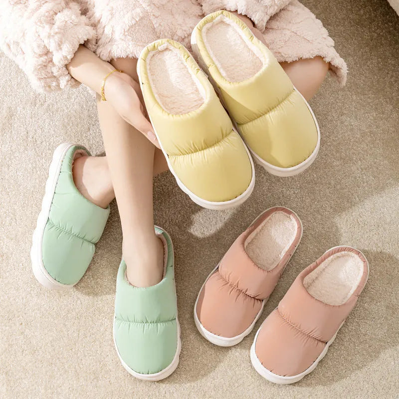 Pair of down cotton winter slippers with artificial leather upper, plush lining, and thick rubber sole.