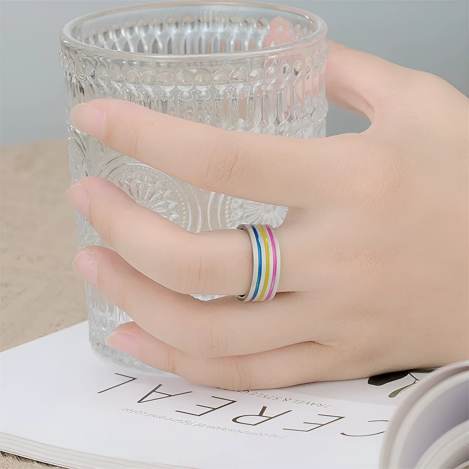 Silver titanium steel ring with rainbow drops of oil pattern and flower shape on white background