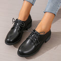 Black women's lace-up work shoes with a thick chunky heel and soft rubber sole.
