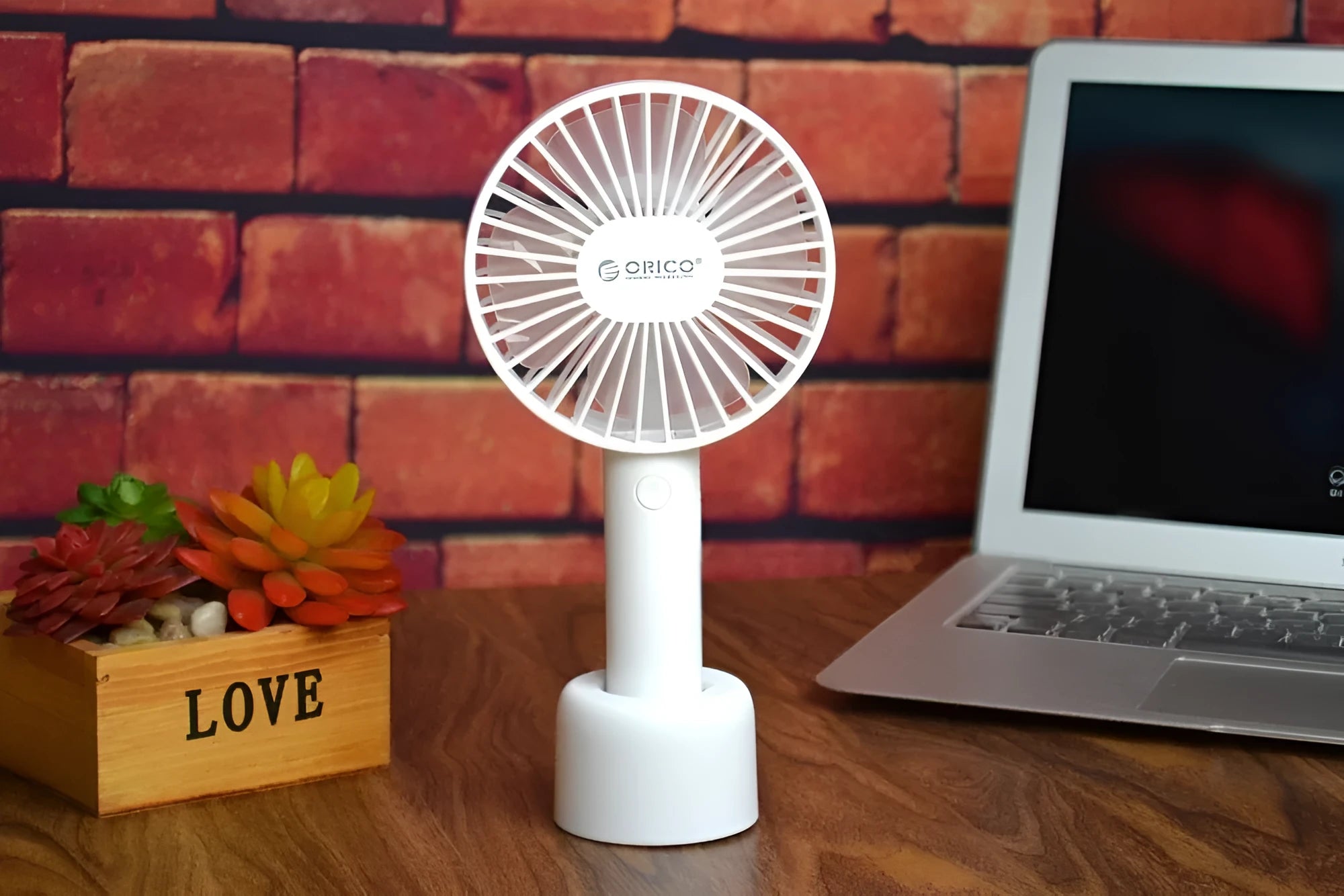 White ORICO FH1 portable USB rechargeable fan with fine line detailing, shown in handheld and desktop positions.