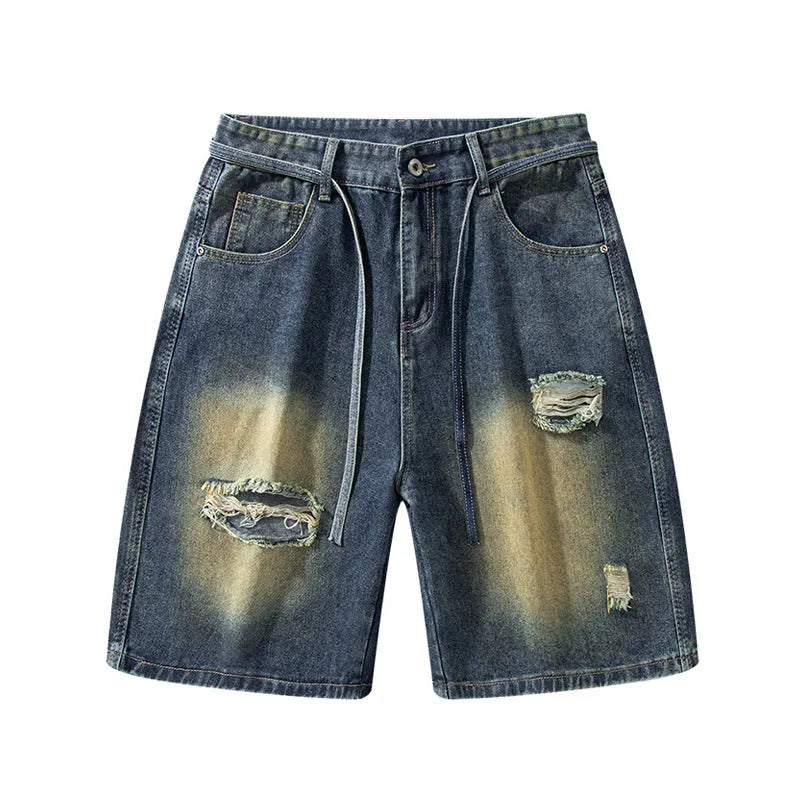 Man wearing loose fit retro blue ripped jeans with distressed details on a street style background.