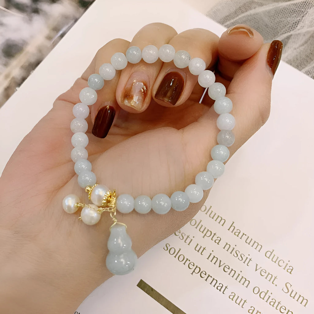 Close-up of a natural emerald jade bracelet with a handcrafted gourd design in Chinese style.