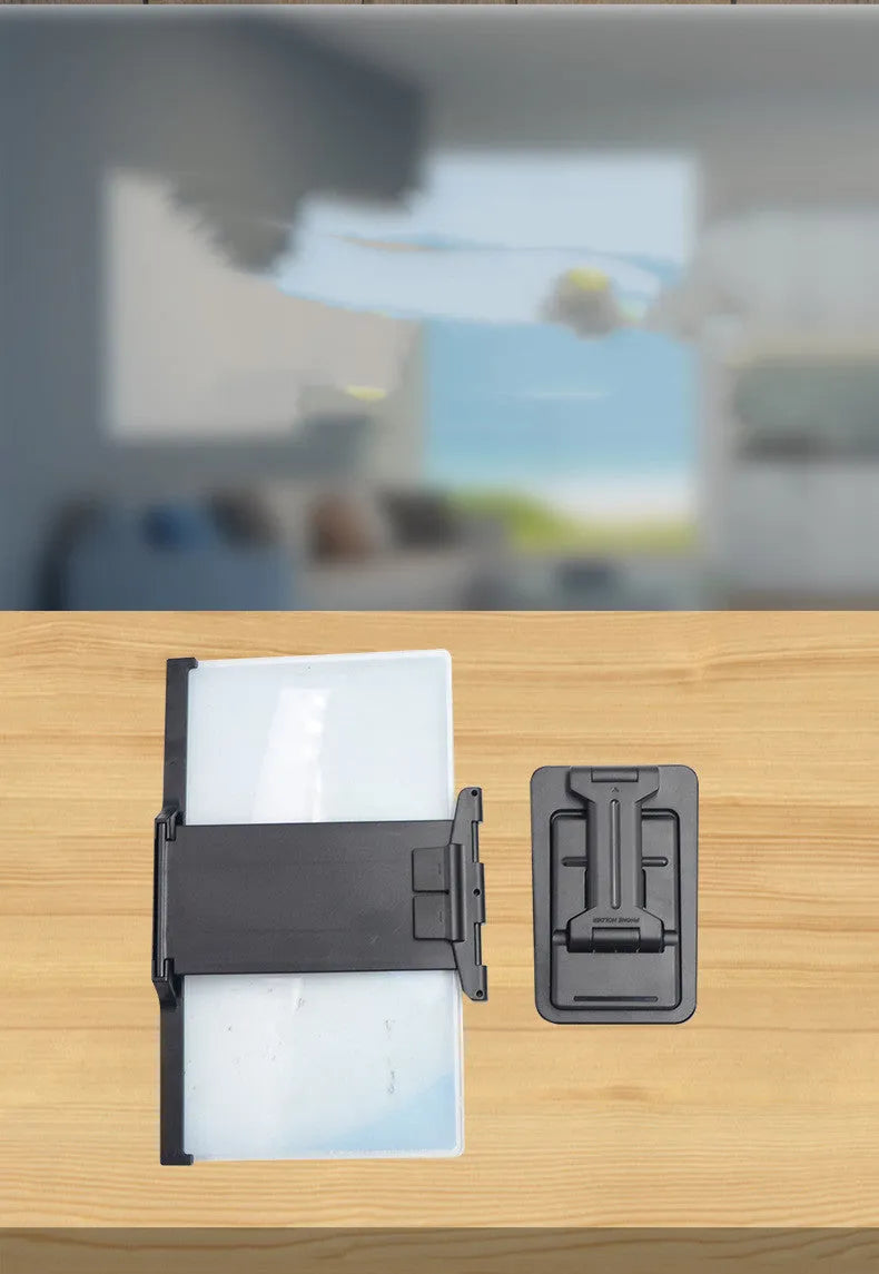 Black folding mobile phone screen amplifier with detachable phone holder on desktop
