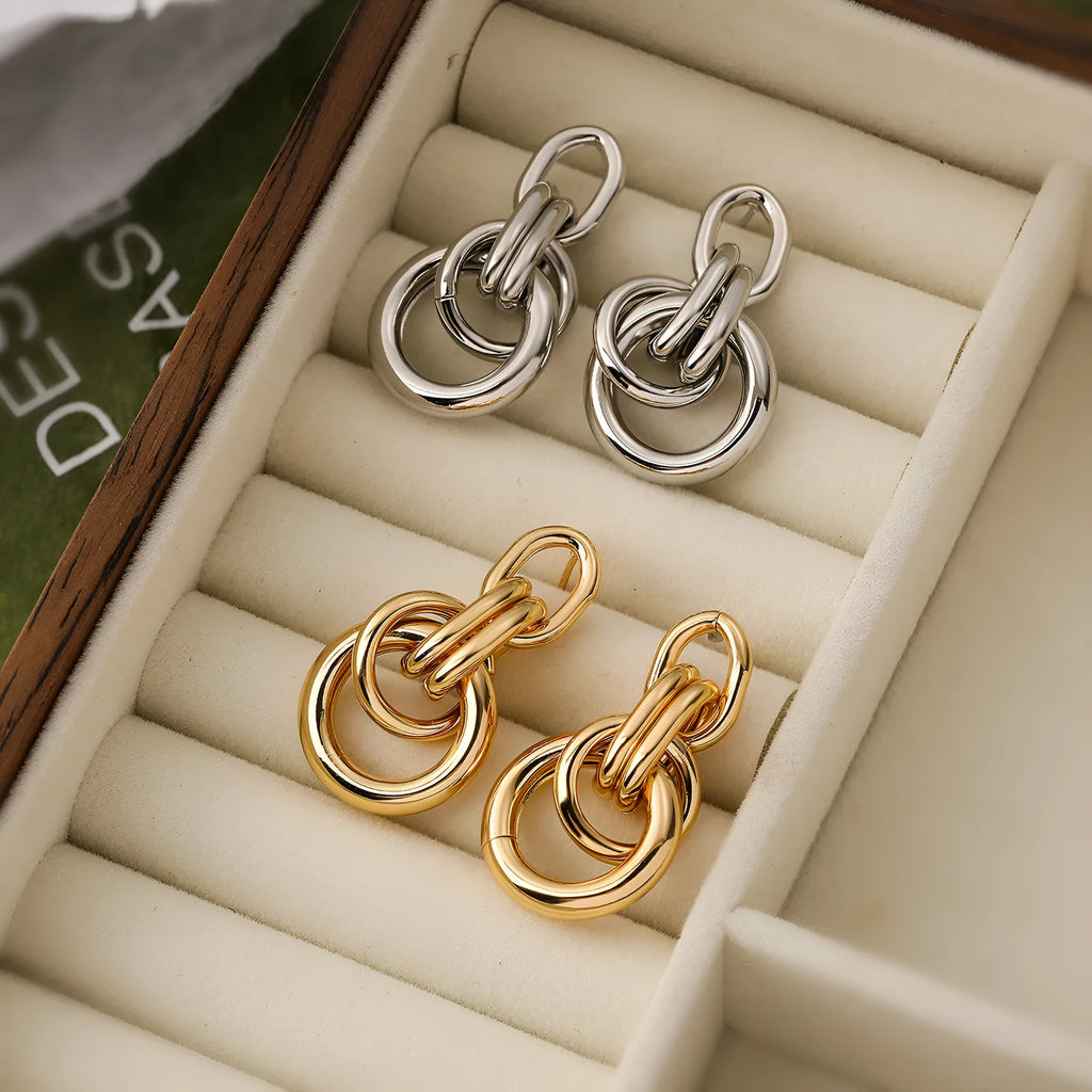 Gold geometric copper earrings with irregular asymmetric design on display