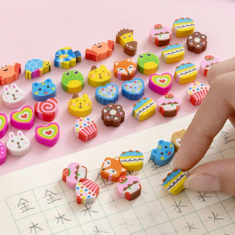 Assortment of colourful TPR cartoon mini erasers showing fruit, animal, and cake designs from a 50-piece pack.