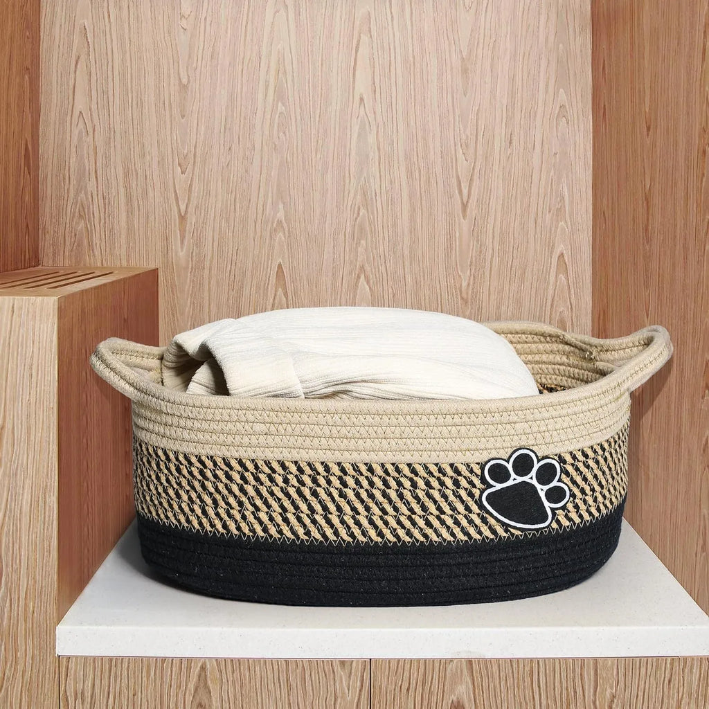 Small light beige hand-woven cotton rope storage basket with a wooden base and a handle.