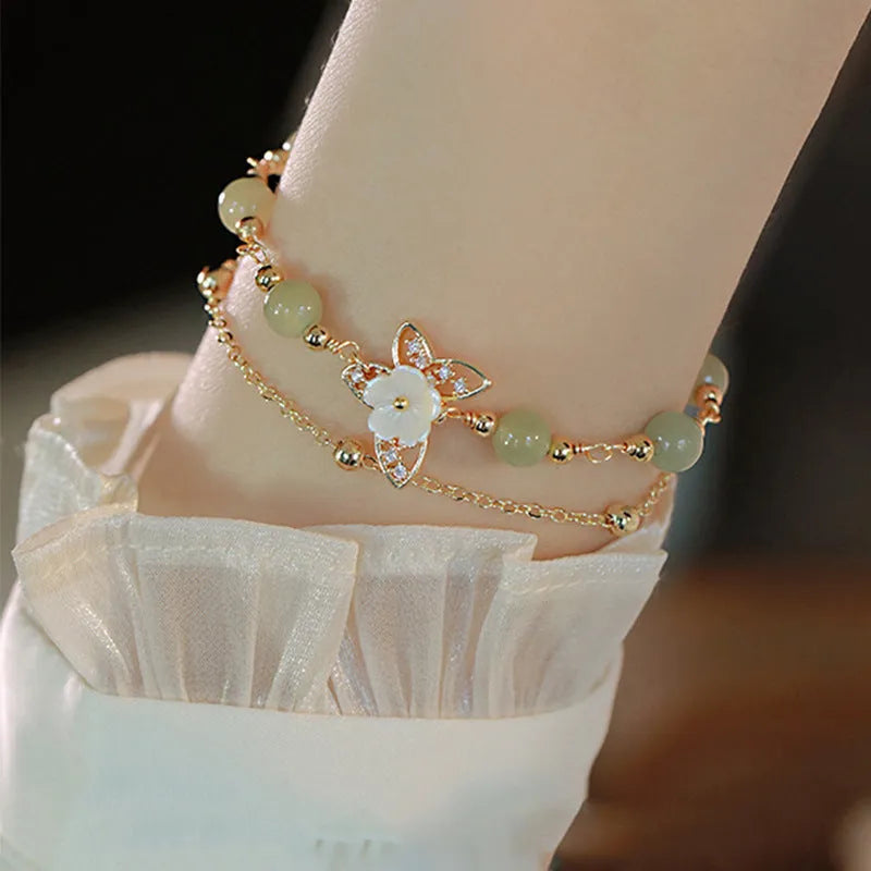 Electroplated copper butterfly bracelet with geometric design and yellow gold finish, showing floral shell motif