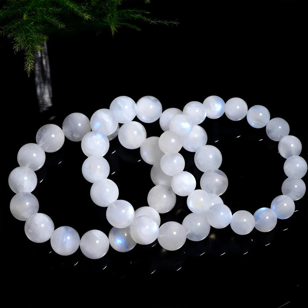 Polished natural blue moonlight moonstone round bead bracelet on white background, showing geometric facets.
