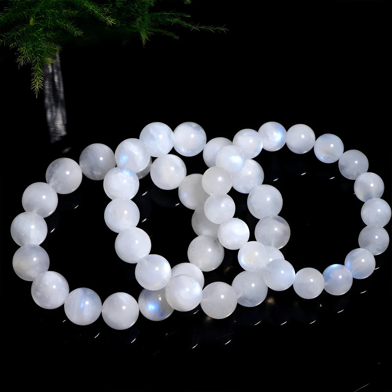 Polished natural blue moonlight moonstone round bead bracelet on white background, showing geometric facets.