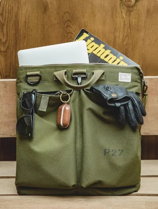 Marden Tooling Helmet canvas messenger crossbody bag in military green, showing vertical square shape and shoulder strap.