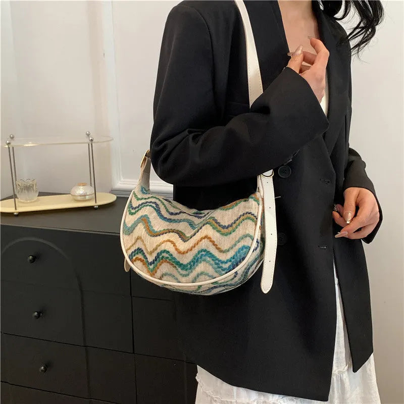 Women's knitted straw woven crossbody bag in corrugated black carrying phone and files