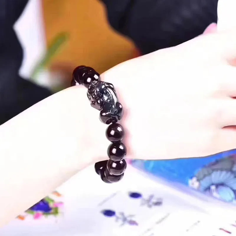 Natural ice colour eye obsidian crystal bracelet on a wrist, showing bead size options.
