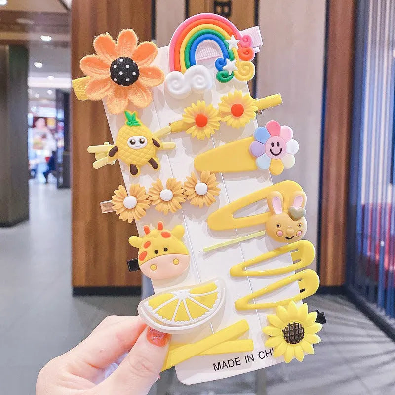14-piece set of colourful toddler hair clips with candy, fruit, rainbow, and butterfly designs on a white background.