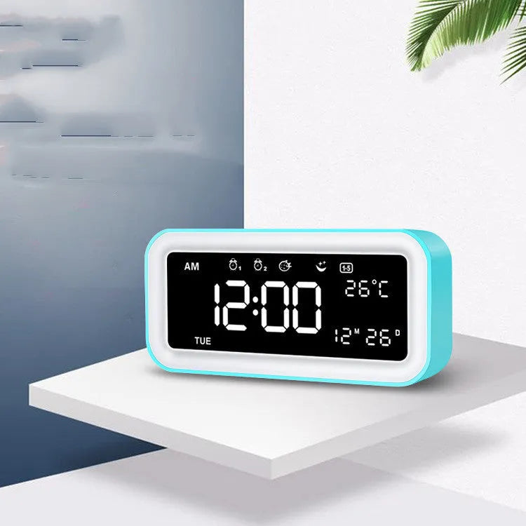 Rectangular blue LED alarm clock with digital display and multicoloured atmospheric lighting on bedside table
