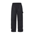 Men's black baggy paratrooper pants with a drawstring waist on a neutral background.