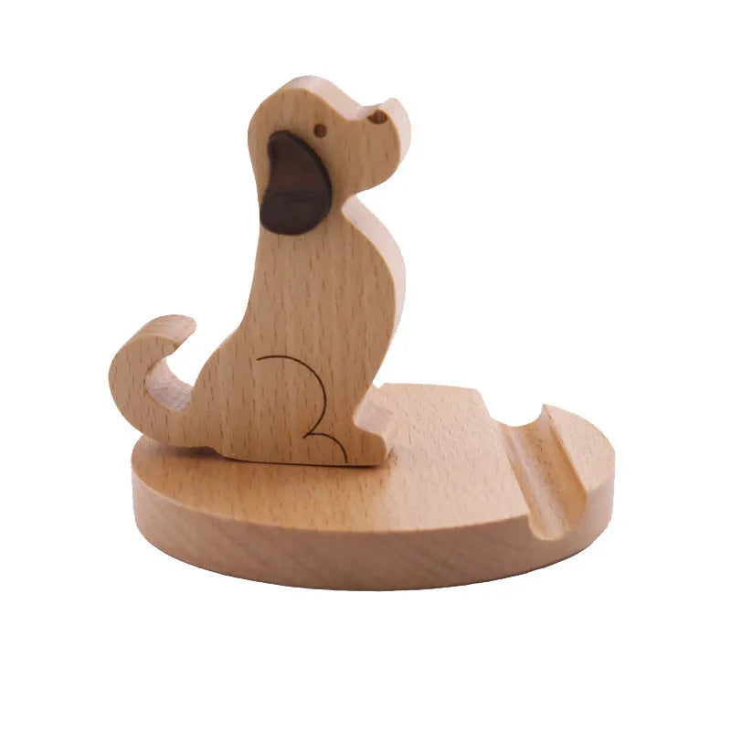Solid wood cartoon puppy phone bracket with brown spray paint on a desk holding a smartphone upright.