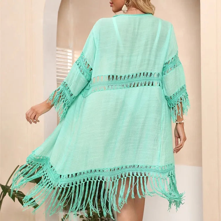 Yellow hand-crocheted acrylic beach cover-up cardigan with tassels on a mannequin