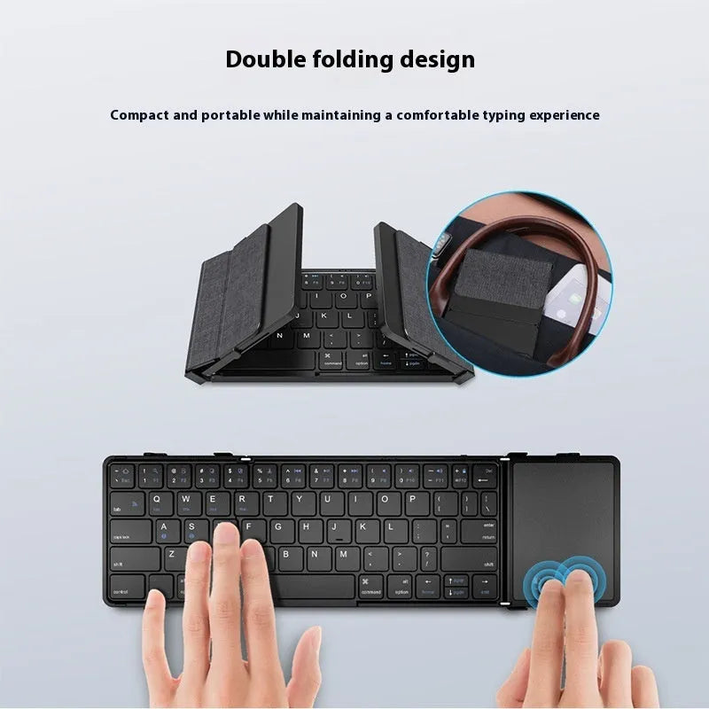 Black folding Bluetooth keyboard shown in open position next to mobile phone