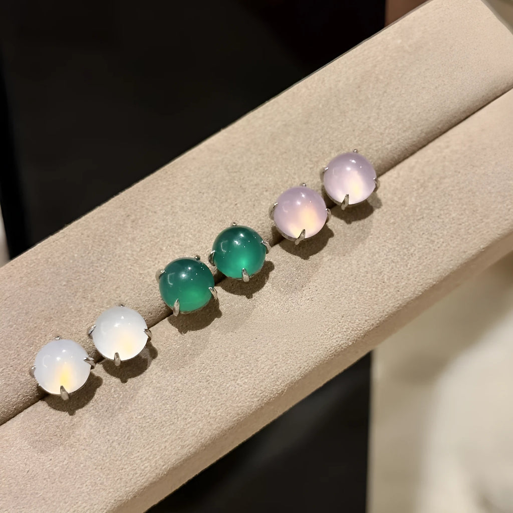 Round egg surface chalcedony stud earrings with four-claw copper settings in green, white, or pink.