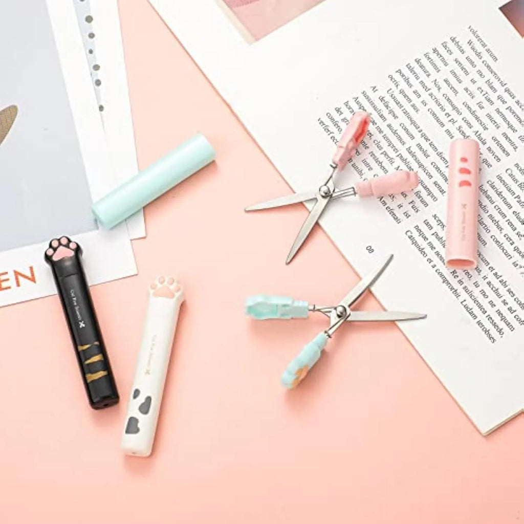 Closed cat paw mini folding scissors showing stainless steel blades and coloured handles.